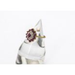 A 9ct gold ruby and diamond oval cluster ring, the oval mixed cut central ruby surrounded by a