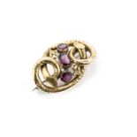 A Victorian garnet mounted knot brooch, the three step cut garnets in claw, closed settings within a