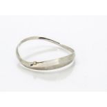 A contemporary diamond set silver bangle, by Barbara Tipple, the elliptical bangle with brilliant