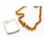 An Art Deco period silver cigarette case, together with a Baltic amber bead necklace (2)