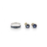 A contemporary 750 marked white metal channel set ring, set with step cut sapphires, ring size L,