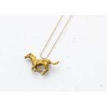 A 9ct gold horse brooch modelled galloping in satin gold finish, together with a fine gold chain,