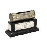 A 1960s novelty silver trophy, the black wooden plinth supporting a section of a log with cut out