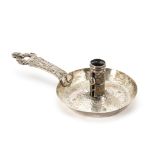 An antique continental white metal chamberstick, probably a marriage, having ornate handle, circular