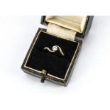 A diamond crossover ring, the old cut in white metal setting, possibly platinum, on a yellow metal