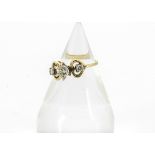 An 18ct gold three stone diamond ring, the modern brilliant cuts in claw settings in a heart