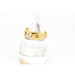 An 18ct gold gentleman's three stone diamond set ring, the graduated band set with three old cut