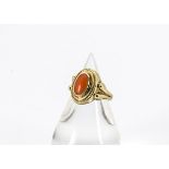 A continental 333 marked coral dress ring, the oval cabochon coral centred within an oval rope twist