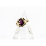 A continental yellow metal and garnet signet ring, the oval mixed cut within a rubbed over mount,