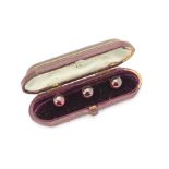 A set of three 18ct gold garnet set dress studs, in fitted Samuel Dixon leather and velvet lined