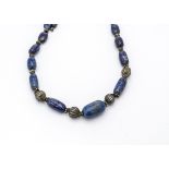 A North Indian string of oval lapis lazuli and silver beads, the graduated oval batons