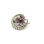 An early 20th Century continental white metal, red paste and simulated pearl crescent brooch, with