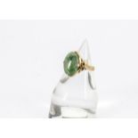 A continental jade signet ring, the oval cabochon jade central stone in four claw setting, ribbon