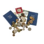 A collection of coins and postal related items, including a blue folder with FDCs and postage items,