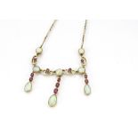A 9ct gold opal and ruby fringe necklace, the cabochon circular opals interspersed with baguette cut