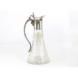 An early 20th Century silver plated and cut glass claret jug, tapered base with engraved floral