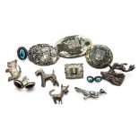 A collection of silver and white metal jewellery, including Mexican and Aztec brooches, a white