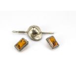 A white metal jockey cap and crop pendant, marked 800 together with a pair of Baltic amber and