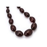 A 'cherry amber' graduated knotted oval bead necklace, the largest bead 3.2cm, the smallest 1cm, 98g
