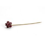 A 19th Century ruby foil backed stick pin, the mixed cut circular rubies in rubbed over settings