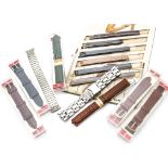 A collection of vintage and modern wristwatch straps, including leather examples in plastic cases by