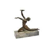 An Art Deco bronze figure of a woman dancing, sliding on her knees holding a dish (glass ball