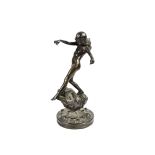 An Art Deco bronze sculpture of a female nude with windswept hair dancing on a rock, circular