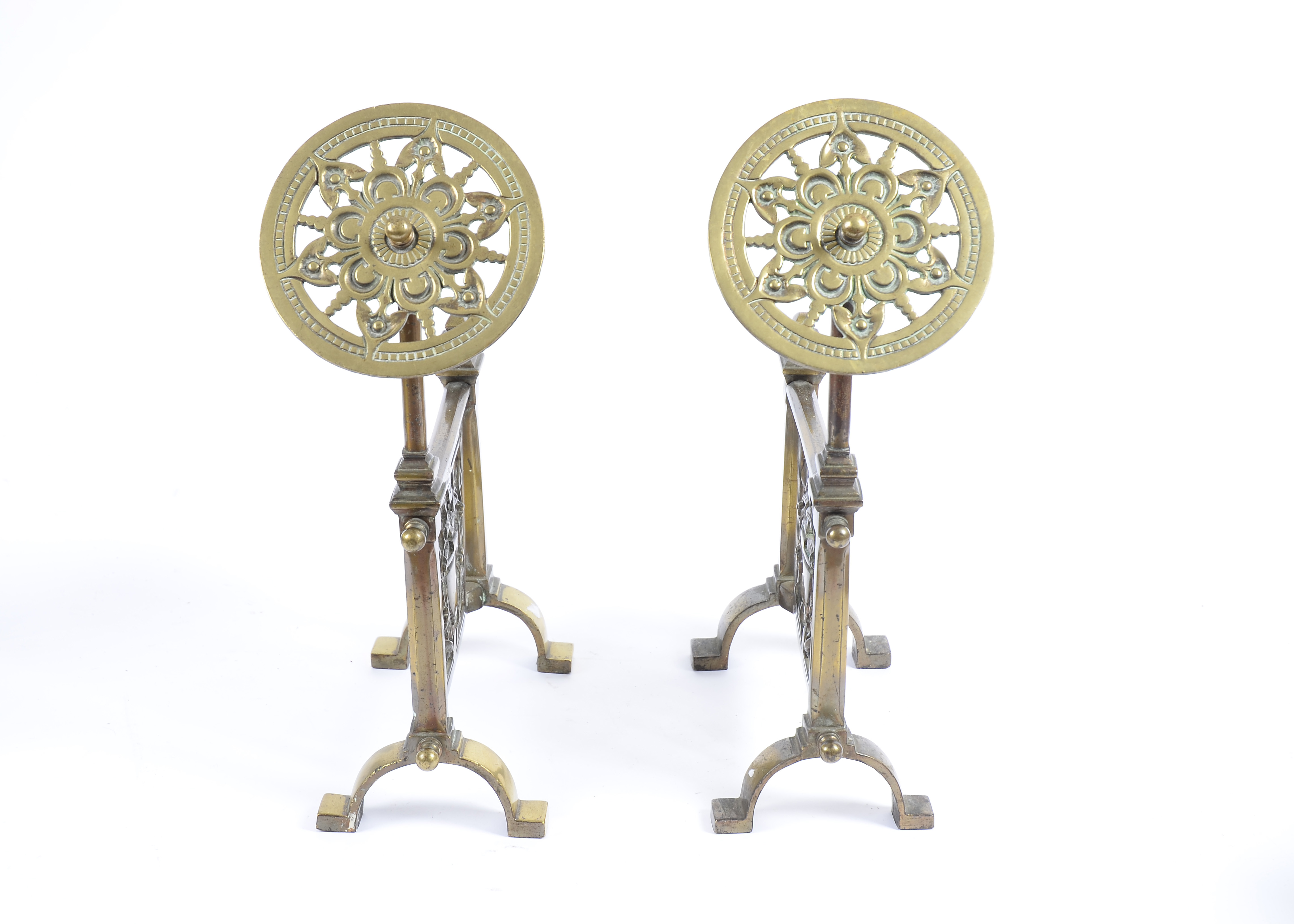 A pair of Victorian brass andirons, each decorated with classical urn and vine leaves, and pierced