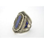 A white metal and lapis lazuli set cuff bangle, the centre featuring a large table cut stone,