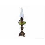 A late 19th Century French oil lamp, gilt brass shaft supporting green glass reservoir painted