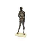 An Art Deco bronze sculpture of a woman standing with hands in her pockets, rectangular marble
