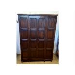 An oak hall cupboard, linen-fold panelled front, single door, bun feet, 127 cm wide x 54 cm deep x