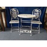 A white painted wrought iron folding garden table and two folding chairs, lattice top and seats,