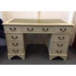 A cream painted pedestal desk, tooled green leather insert to top, nine drawers, 122 cm wide x 61 cm