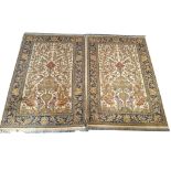 A pair of Persian woollen rugs, ivory ground with vases of flowers, trees and birds, floral indigo