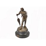 An Edwardian spelter figure of a dandy, bowing whilst carrying satchel and umbrella, turned wooden