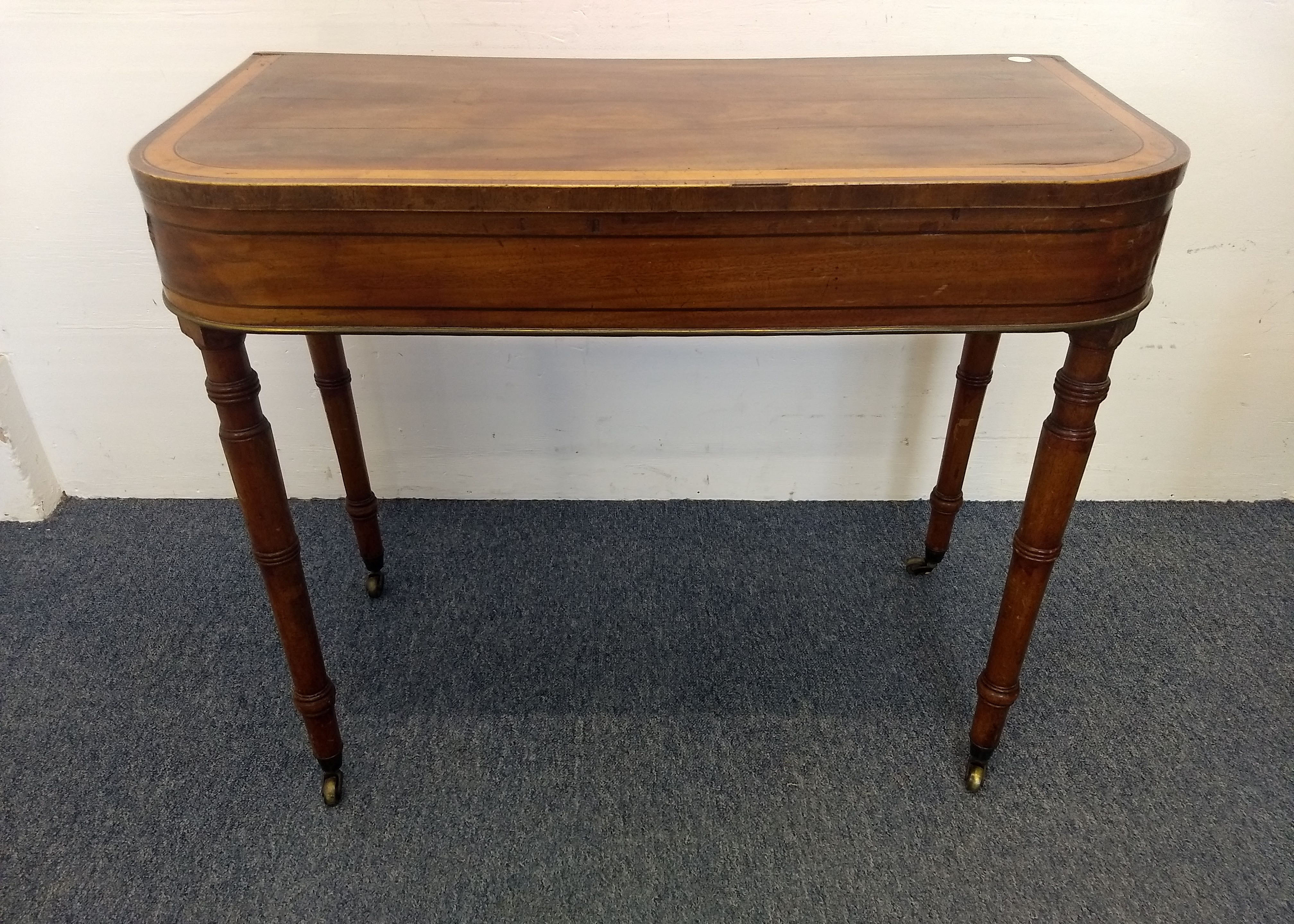 A Georgian mahogany card table, satinwood inlay, ebony stringing and brass edging, hinged top