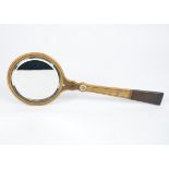 An Edwardian bevelled hand mirror, with a wooden frame inlaid with mother of pearl and straw work,