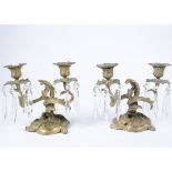 A pair of Louis XV style bronze twin branch candlesticks, decorated with foliate scrolls, on