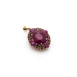 An 9ct gold oval ruby set pendant, the central oval ruby in four claw setting surrounded by two rows