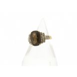 A 9ct gold smoky quartz and diamond set dress ring, the faceted central stone in claw setting having