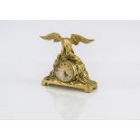 A small late 19th century French gilt clock, with eagle and snake on craggy base and inset watch