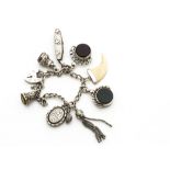 A silver curb linked charm bracelet, with padlock clasp, two swivel fobs, silver mounted manicure