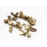 A 9ct gold padlock clasp curb linked charm bracelet, with eighteen gold charms including dice, Irish