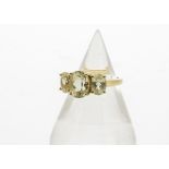 A 9ct gold three stone set spodumene dress ring, the three oval mixed cut stones in claw settings on