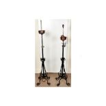 A pair of 19th Century wrought iron lamp holders, with copper reservoirs and decorated with scroll