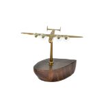 A 20th Century desktop model of an aircraft, featuring a brass B24 upon a wooden propeller base,