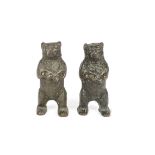 A pair of cast iron metalwork bears intended as money boxes, both stand upright upon two feet,