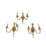 A trio of French Rococo style two arm gilt metal wall sconces, each with a central cartouche and