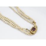 A cultured pearl three row necklace, the knotted graduated rows united by a 9ct gold seed pearl